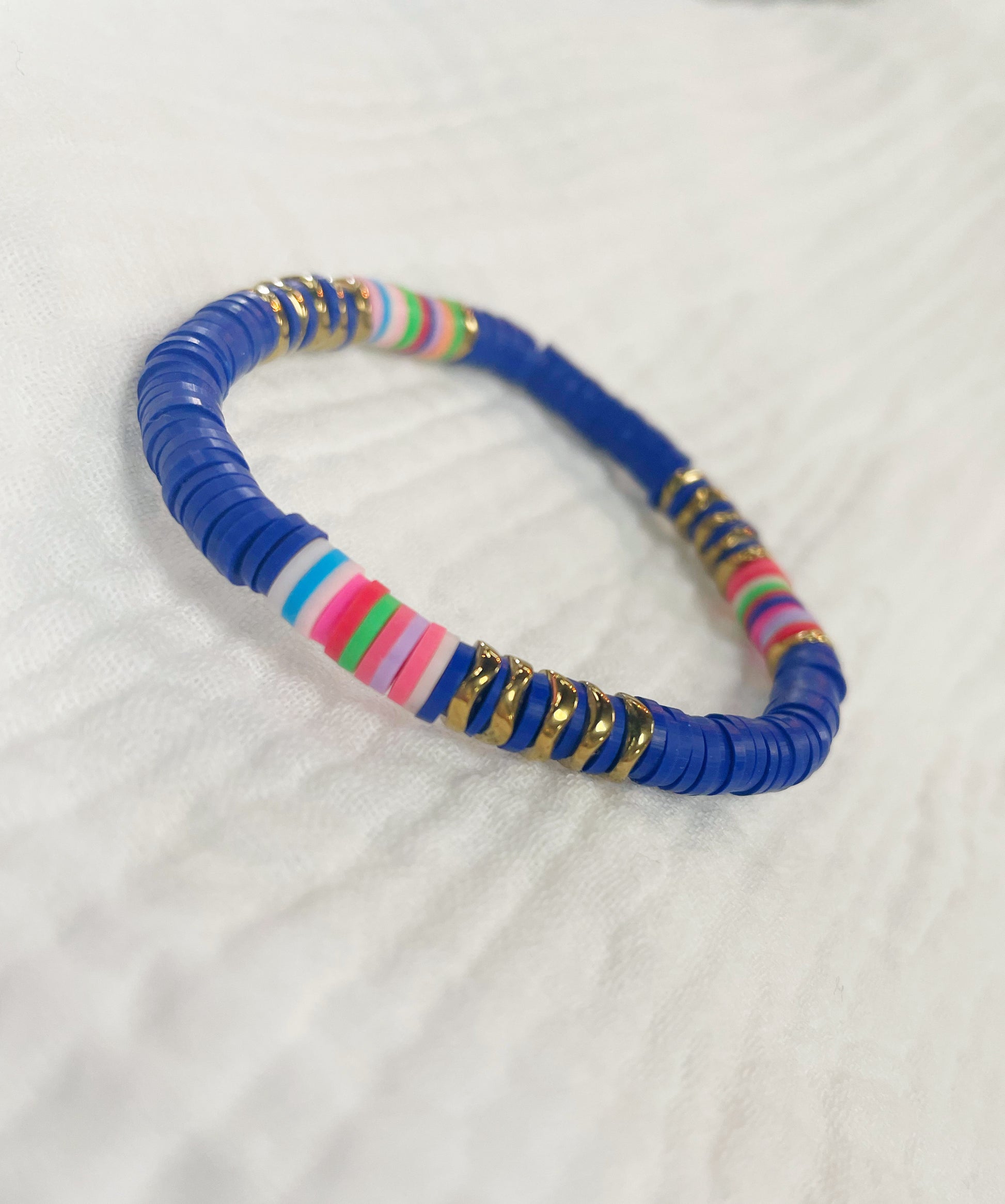 Cobalt blue soft rubber disc beaded stretch bracelet with a few multi colored and gold disc beads