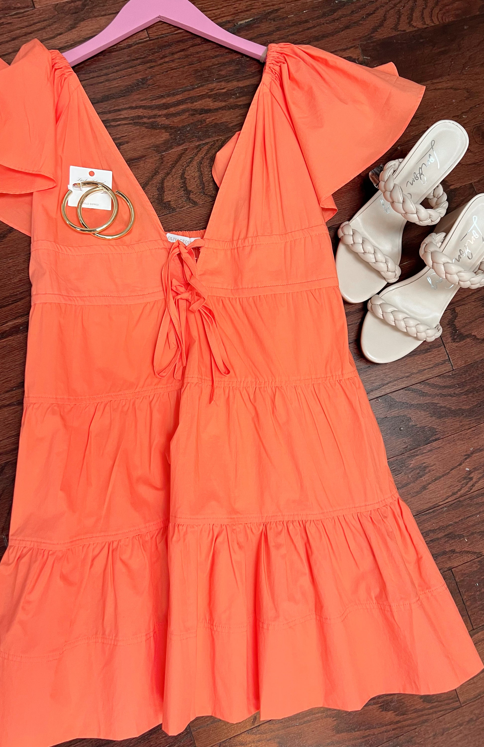 Off white slip-on block heel with 2 braided straps paired with orange short-sleeve mini dress